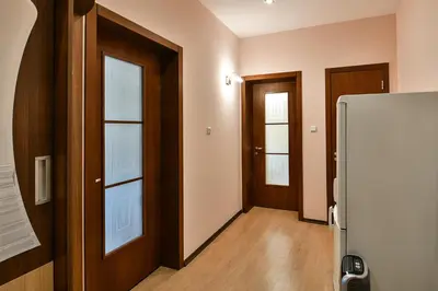 a hallway with two doors and a refrigerator at Budget central next to sea garden and beach in Varna City
