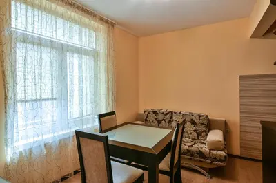a dining room with a table and a chair and a window at Budget central next to sea garden and beach in Varna City