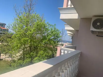 a balcony with a white railing and a tree at Студио Симона 4 - първа линия море in Lozenets