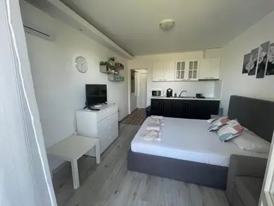 a small bedroom with a bed and a kitchen at Студио Симона 4 - първа линия море in Lozenets