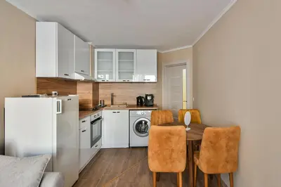 a kitchen with a table and chairs and a refrigerator at Top location flats in Varna in Varna City