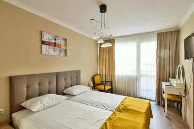 a bedroom with a bed with a yellow blanket on it at Top location flats in Varna in Varna City