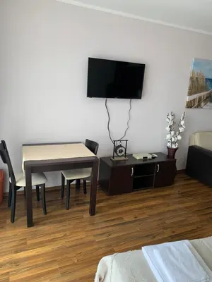 a living room with a table and a tv at Студио Нели- Созополистайл Клуб in Sozopol