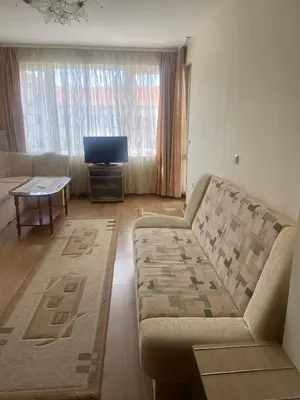 a living room with a couch and a tv at Pomorie Apartment in Pomorie