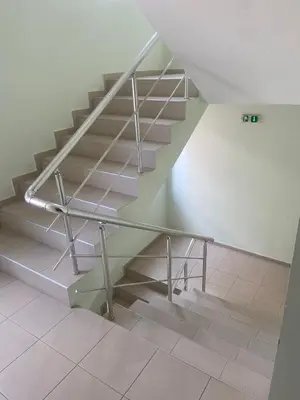 a staircase with a metal railing in a room at Pomorie Apartment in Pomorie