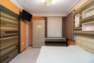 a small bedroom with a bed and a television at Cozy central flat in Varna Downtown in Varna City