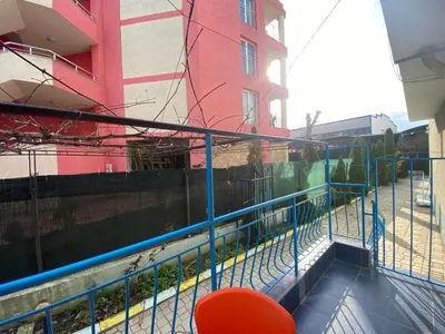 a red chair sitting on a balcony next to a building at VIOLET GARDEN 2 Veranda Apartment in Sunny Beach