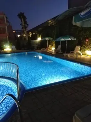 a large blue swimming pool at night at VIOLET GARDEN 2 Veranda Apartment in Sunny Beach
