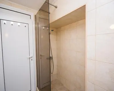 a shower with a glass door in a bathroom at Summer Square - 2 bedrooms Retro Flat with great location, 1st fl in Burgas City