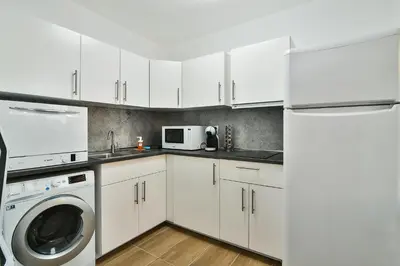 a kitchen with white cabinets and a washer and dryer at Central 3BR with parking nearby Opera in Varna City