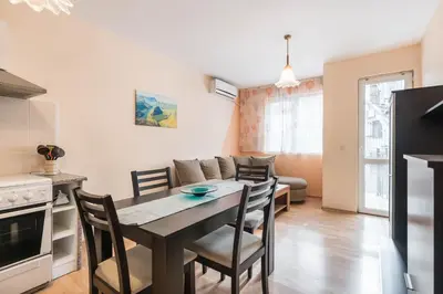 a kitchen and living room with a table and chairs at Sea&Park Apartment in Varna City