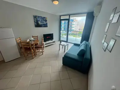 a living room with a blue couch and a table at Large apartment in Sunny Beach in Sunny Beach