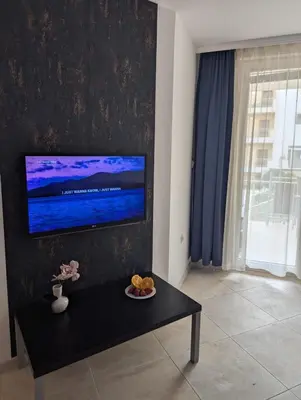 a living room with a flat screen tv on a wall at Sunny place in Sveti Vlas