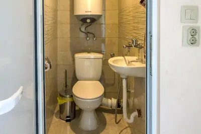 a bathroom with a toilet and a sink at Central train station Flat with port view in Varna City