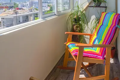 a colorful rocking chair sitting in front of a window at Central train station Flat with port view in Varna City