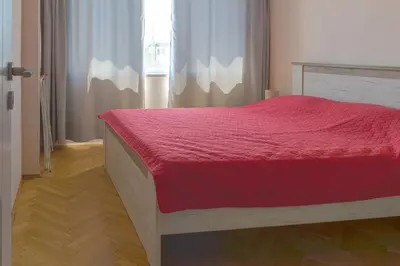 a bedroom with a bed with a red bedspread at Central train station Flat with port view in Varna City