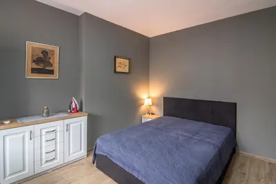 a bedroom with a bed with a blue bedspread at Top location in center and paid parking in Varna City