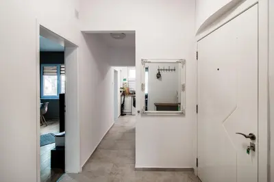 a hallway with white walls and a mirror on the wall at Top location in center and paid parking in Varna City