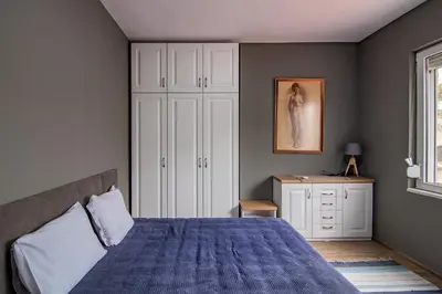 a bedroom with a blue bed and a white cabinet at Top location in center and paid parking in Varna City