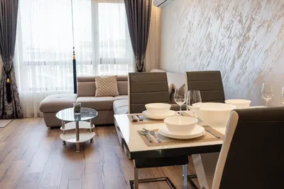 a living room with a table and a couch at M1 Pool and Beach View Apartment in Burgas City