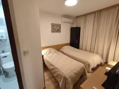 a hotel room with two beds and a toilet at Longoz in Bliznatsi