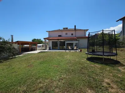 a yard with a swing in front of a house at Longoz in Bliznatsi