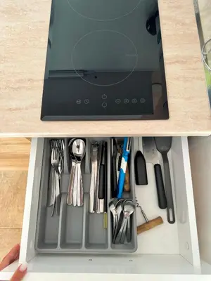 a drawer in a cabinet filled with utensils at Студия Sea Breeze in Sveti Vlas