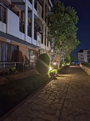 an empty street in front of a building at night at Студия Sea Breeze in Sveti Vlas