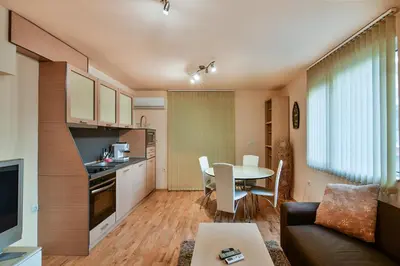a kitchen and a living room with a table and chairs at Budget 1BR flat downtown Varna in Varna City