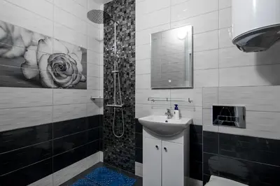 a black and white bathroom with a sink and a shower at Super Central flat in Varna in Varna City