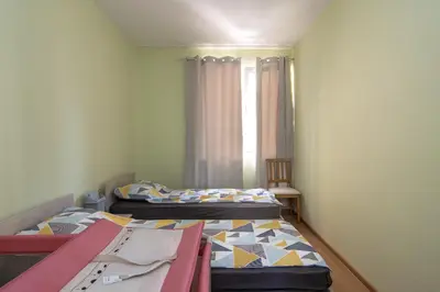 two beds in a small room with a window at Super Central flat in Varna in Varna City