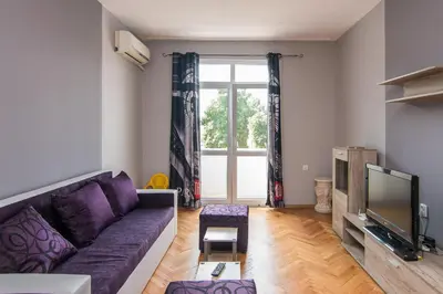 a living room with a purple couch and a tv at Super Central flat in Varna in Varna City