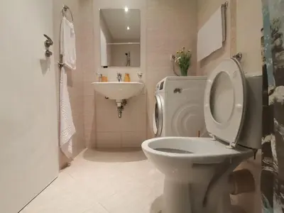 a white bathroom with a toilet and a sink at Апартамент Orange в местност Каваци, Созопол in Sozopol