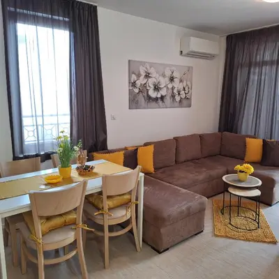 a living room with a couch and a table at Апартамент Orange в местност Каваци, Созопол in Sozopol