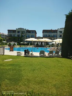 a swimming pool with chairs and umbrellas at Апартамент Orange в местност Каваци, Созопол in Sozopol
