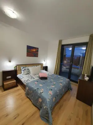 a bedroom with a bed and a large window at Apartament Topalov in Burgas City