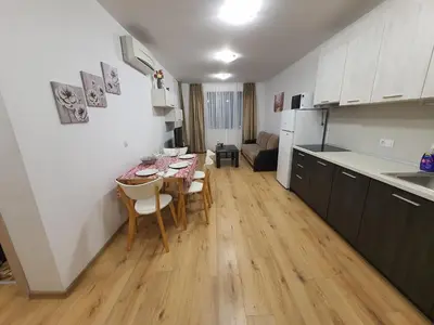 a kitchen and a dining room with a table and chairs at Apartament Topalov in Burgas City