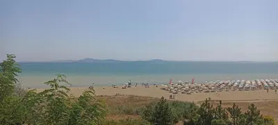 a beach with a bunch of umbrellas and the ocean at Apartament Topalov in Burgas City