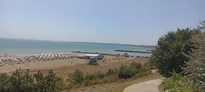 a beach with a bunch of umbrellas and the water at Apartament Topalov in Burgas City