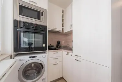 a kitchen with a washing machine and a microwave at Studio Porto in Varna City