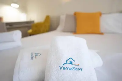 a hotel room with towels on a bed at Studio Porto in Varna City