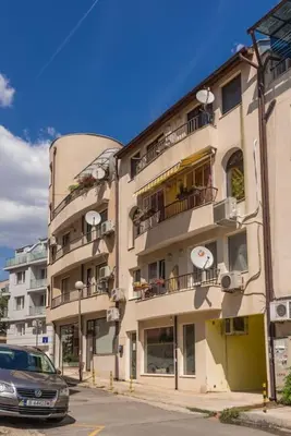 a tall building with a car parked in front of it at Studio Porto in Varna City