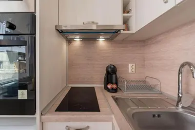 a small kitchen with a sink and a stove at Studio Porto in Varna City
