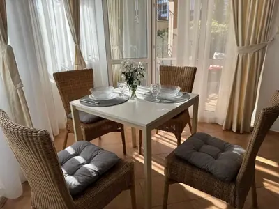 a white table with chairs and a vase of flowers on it at Atia Resort in Chernomorets