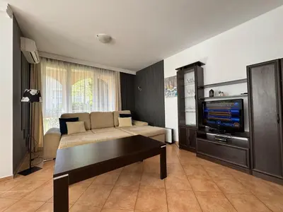 a living room with a couch and a tv at Atia Resort in Chernomorets