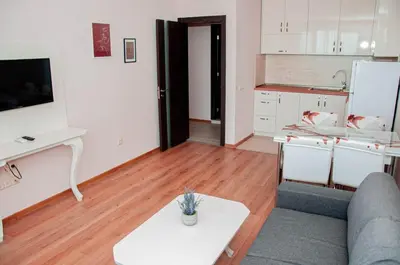 a living room with a couch and a table and a kitchen at Kristin Palace in Obzor