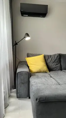 a couch with a yellow pillow on it in a room at Blue Heaven Apartment Kavaci Sozopol in Sozopol