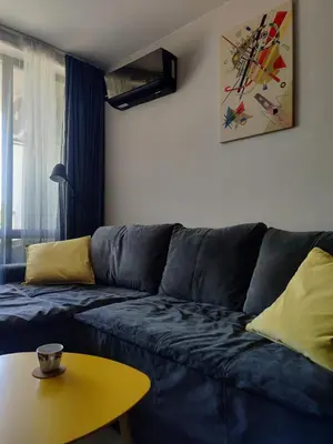 a living room with a blue couch and a yellow table at Blue Heaven Apartment Kavaci Sozopol in Sozopol