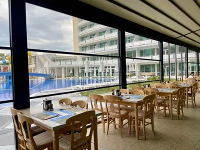 a restaurant with tables and chairs and a building at Grand Hotel Nirvana - All Inclusive & Free Beach Access in Sunny Beach