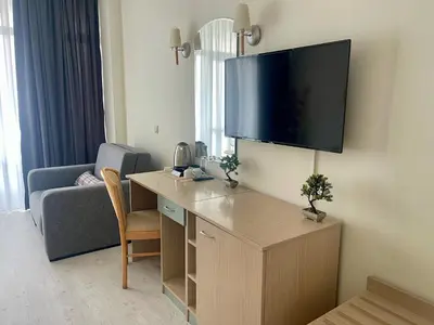 a living room with a couch and a tv on the wall at Grand Hotel Nirvana - All Inclusive & Free Beach Access in Sunny Beach